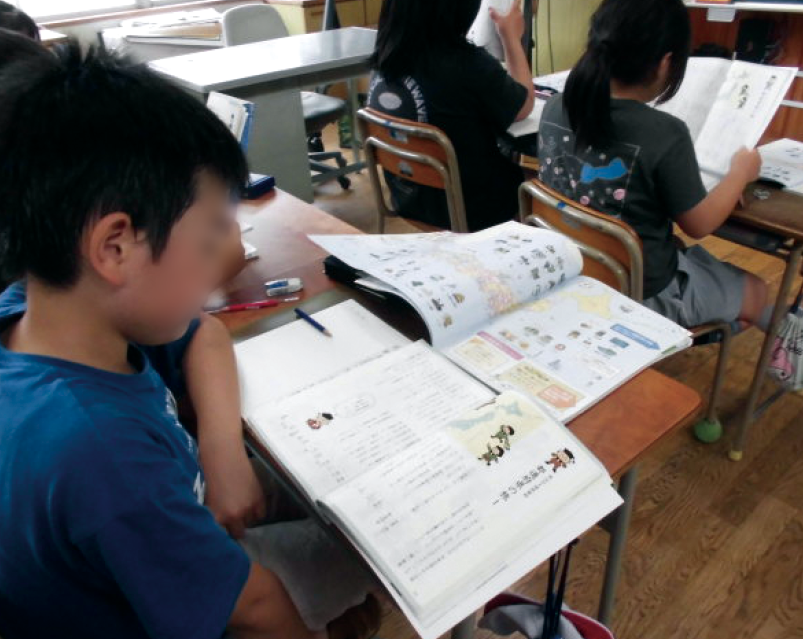 地図帳を見ながら漢字を学習する児童